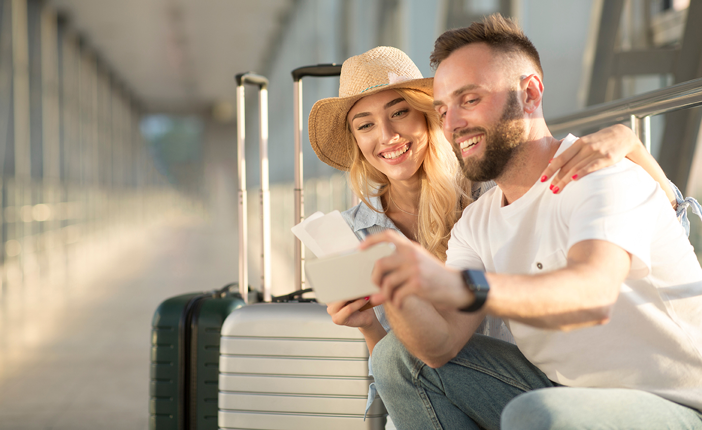 Happy couple taking selfie in airport, waiting for boarding Image of a couple planning their travel